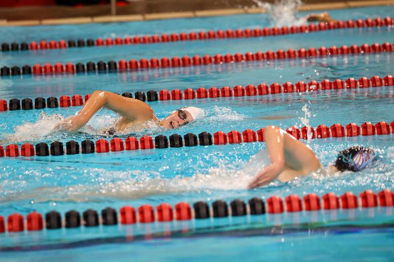 Bradley-Bourbonnais' Isabelle Trudeau looks to lap Kankakee's Cecelia Christensen in the 500-yard freestyle race during Bradley-Bourbonnais' victory over Kankakee and Bishop McNamara in the All-City swim meet on Tuesday, Sept. 9, 2025.