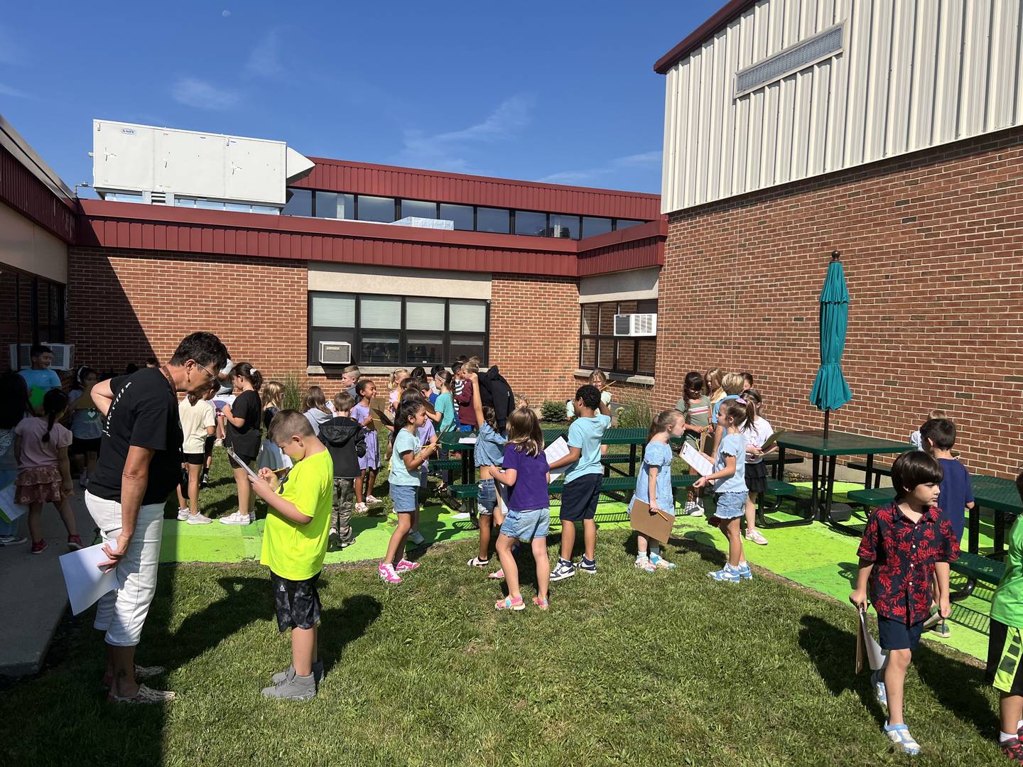 Teacher Kecia Griffin talks to a student during a class exercise in Aug. 2025 in the Amy Roeder Memorial Garden at Woodstock's Westwood Elementary School.