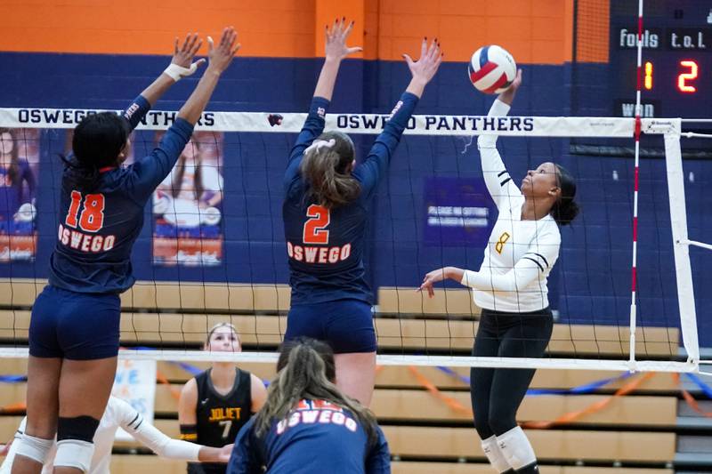 Joliet West's Eden Eyassu (8) goes up for a kill attempt against Oswego’s Maya Norlin (18) and Kelsey Foster (2) during a volleyball match at Oswego High School on Thursday, October 24, 2024.