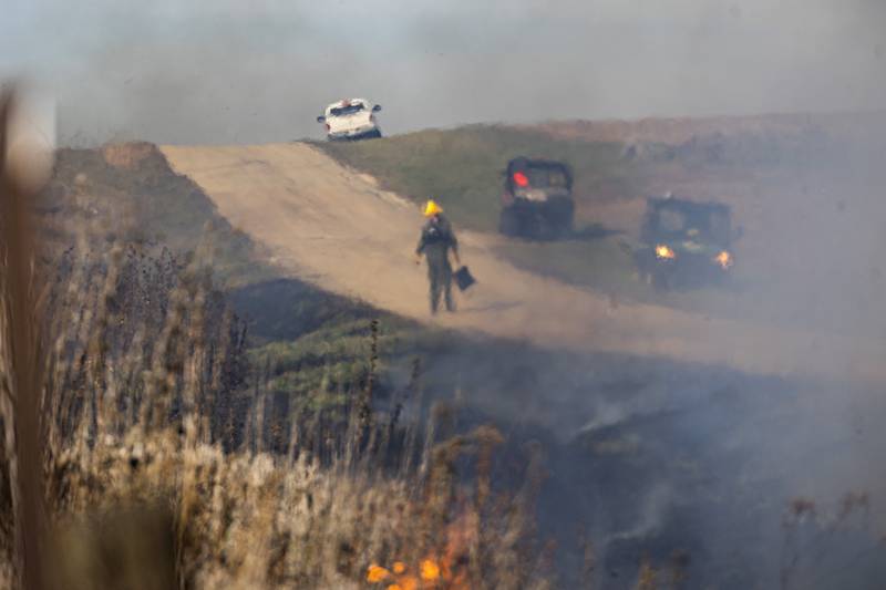 Smoke and heat create a haze in the air as crews work on the burn Tuesday, Nov. 14, 2023.