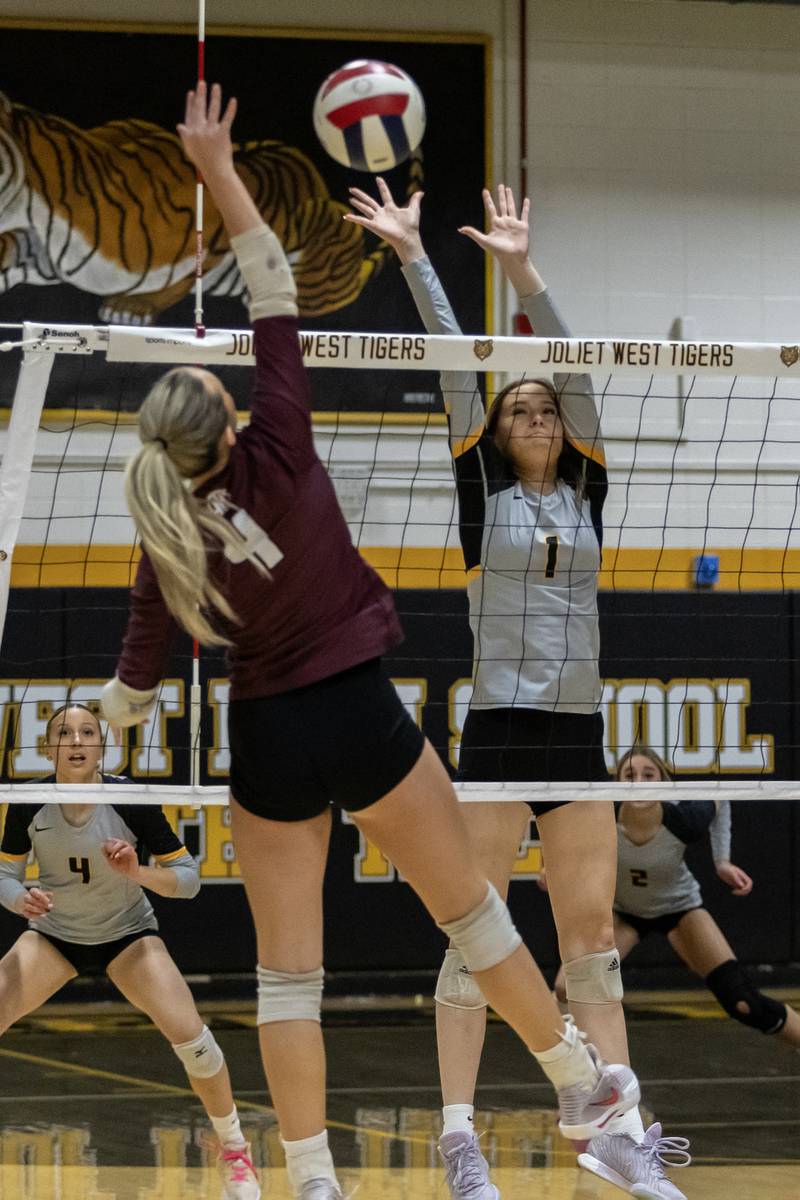 Joliet West's Emma Salerno blocks as Lockport's Mikayla Marshall spikes during a 4A Sectional Finals varsity volleyball game at Joliet West on Nov. 6, 2025.