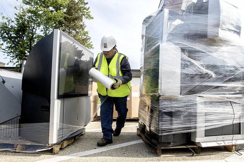 Ubaldo Jemenez wraps up old TV sets that were dropped off during an electronic waste recycling collection May 21, 2016, in McHenry.
