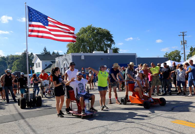 Maple Park Fun Fest volunteer Hillary Joy announces the teams for a heat of the 2024 Maple Park Fun Fest Toilet Bowl Races on Saturday, Aug. 31, 2024 in Maple Park.