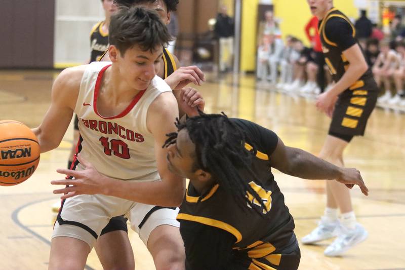 Jacobs’ Emaan Thomas, center, guards Barrington’s Oliver Gray, left, during Hinkle Holiday Classic varsity boys basketball tournament action on Monday, Dec. 23, 2024 at Jacobs High School in Algonquin.
