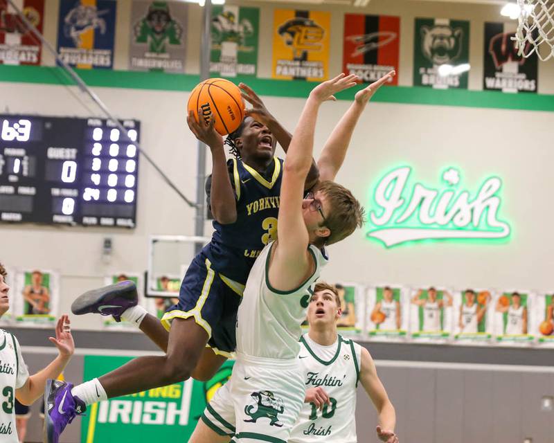 Yorkville Christian's Jayden Riley (3) hangs in the air while drawing a foul on a shot over the defense during their Class 2A Seneca Sectional final basketball game between Bishop McNamara at Yorkville Christian, March 6, 2026 in Senaca.