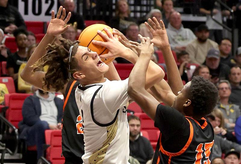 Sycamore's Josiah Mitchell tries to get a shot up between two DeKalb defenders during their game Friday, Jan. 31, 2025, in the FNBO Challenge in the Convocation Center at Northern Illinois University in DeKalb.