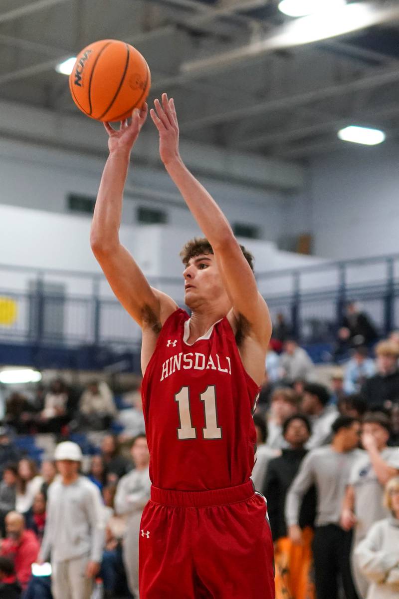Hinsdale Central's Cole Bero (11) shoots a three pointer against Oswego East during a hoops for healing tournament basketball game at Oswego East High School on Tuesday, Nov. 26, 2024.