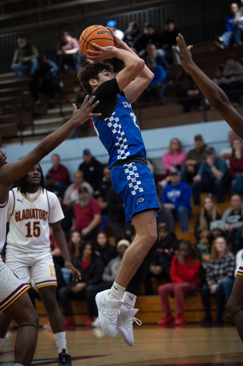 Clifton Central's Mayson Mitchell, center, elevates for a shot in a game against Christ the King in the Kankakee Holiday Tournament at Kankakee High School on Saturday, December 27, 2025.