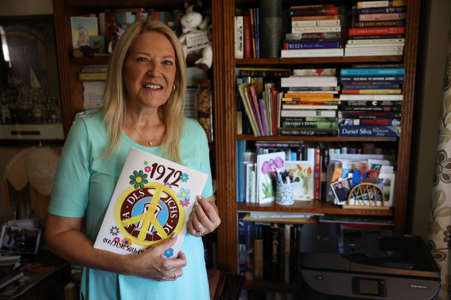 Marianne Wolf-Astrauskas is seen on Tuesday, Sept. 20, 2022, in Orland Park, holding the book distributed at her 50th reunion earlier in September. Wolf-Astrauskas created this 70-page book for the combined 50th reunion of the former Catholic High School and St. Francis Academy.