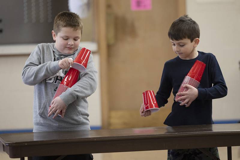 Fourth grader Hunter Kremske (left) and third grader Carter Bilharz compete in a cup sorting game Tuesday, Jan. 30, 2024, at St. Anne’s school in Dixon. St. Anne’s spent a few hours of fun for the day in celebration of Catholic Schools Week.