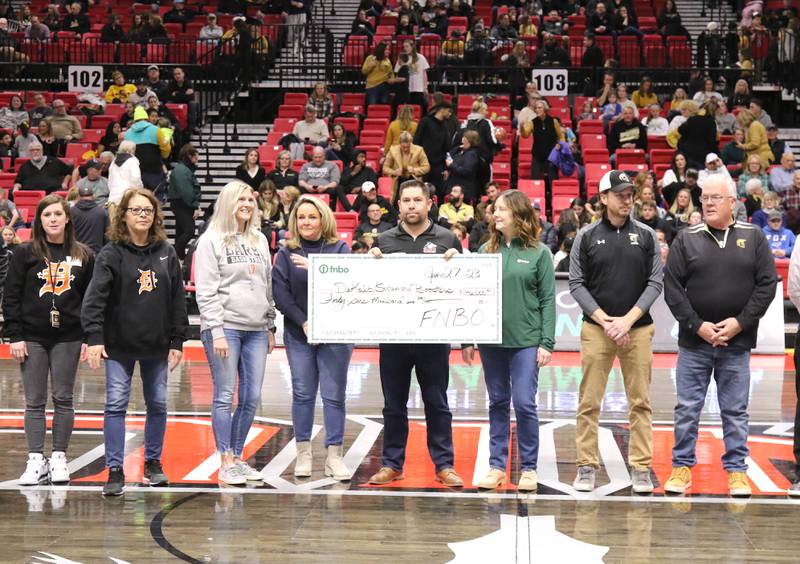 Representatives from Sycamore and DeKalb High Schools accept the check from representatives from First National Bank check from during the First National Challenge Friday, Jan. 27, 2023, at The Convocation Center on the campus of Northern Illinois University in DeKalb.