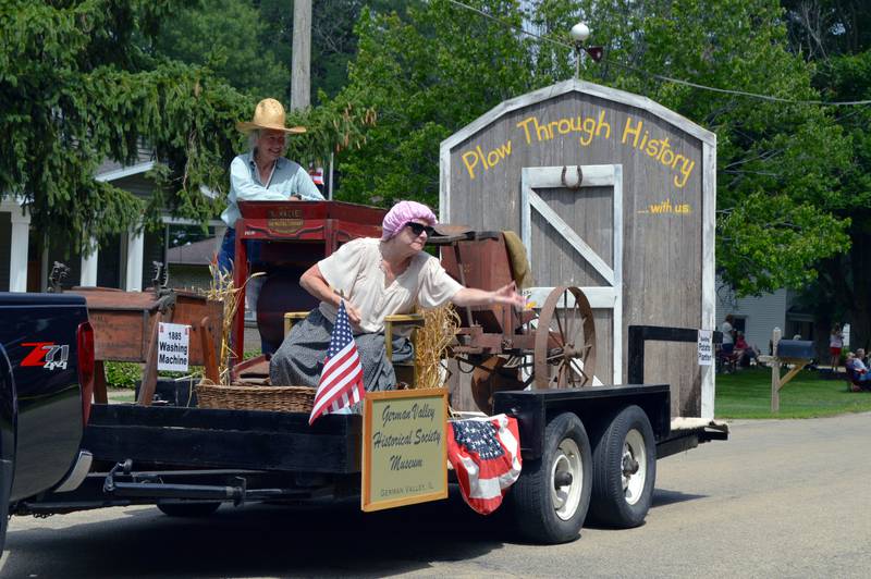 Representatives of the German Valley Historical Society Museum toss candy from their float to those attending the German Valley Days parade on July 16.