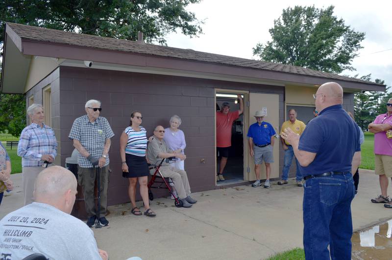 Polo Mayor Doug Knapp (right) addresses members of the Burkardt family and the Polo Lions Club during the dedication of a new concession stand and storage shed on July 29, 2024, at Millard Deuth Westside Park.