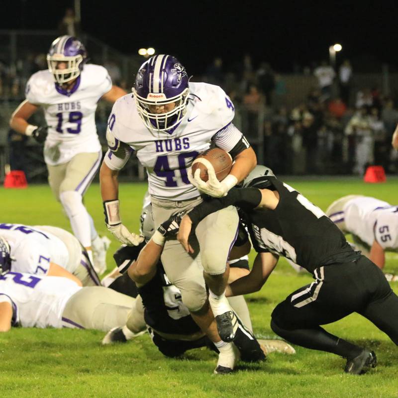 Rochelle's Roman Villalobos (40) runs through the tackle of a Kaneland defender during Friday's game in Kaneland.