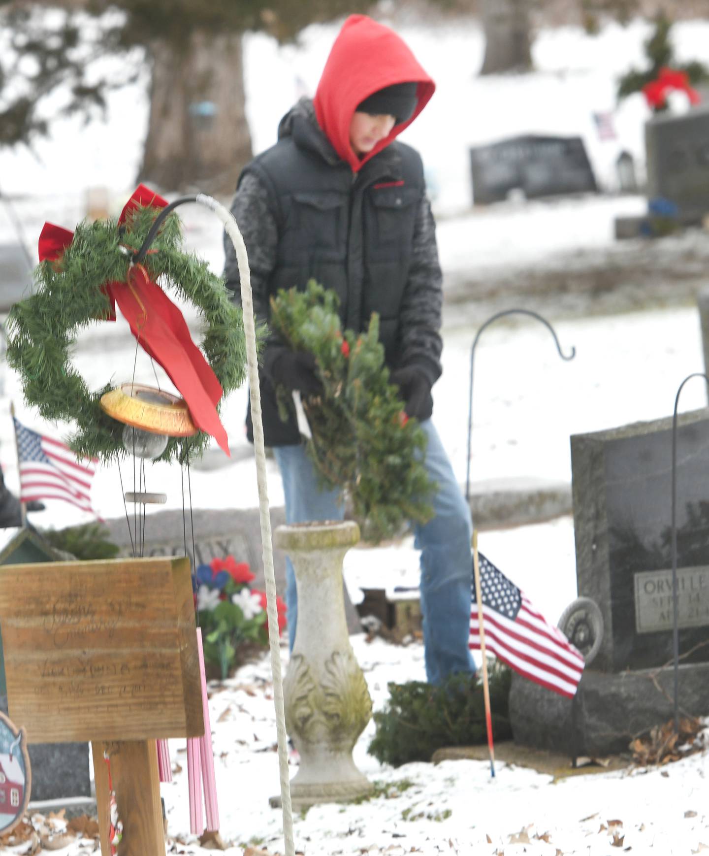 Devyn Stevents, 12, of Oregpn places a wreath on a veteran's grave in Daysville Cemetery, southeast of Oregon on Dec. 17 during the Wreaths Across America project.