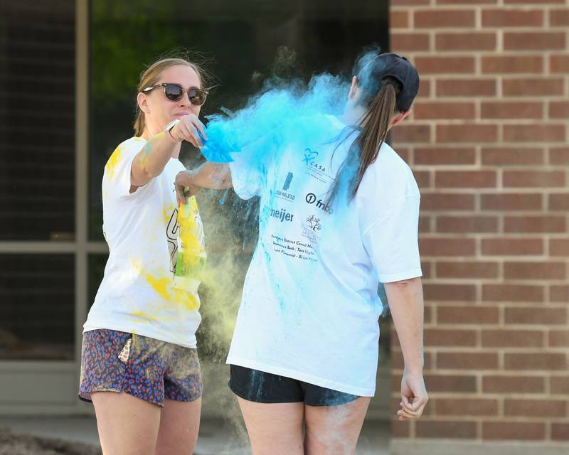 Brittany Calendo (left) and Nicole Walsh, both of Sycamore, toss powdered color on each other on Saturday, June 7, 2025, before the start of the CASA DeKalb County 5K Color Run held at the Sycamore Middle School.