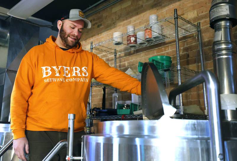 Steve Byers, co-owner of Byers Brewing Company, looks in one of the brewing kettles Friday, Jan. 6, 2023, in the production area at the brewery and taproom in DeKalb. Byers is planning an expansion of its operations to include another location,  216 N. Sixth St., in DeKalb for production only.