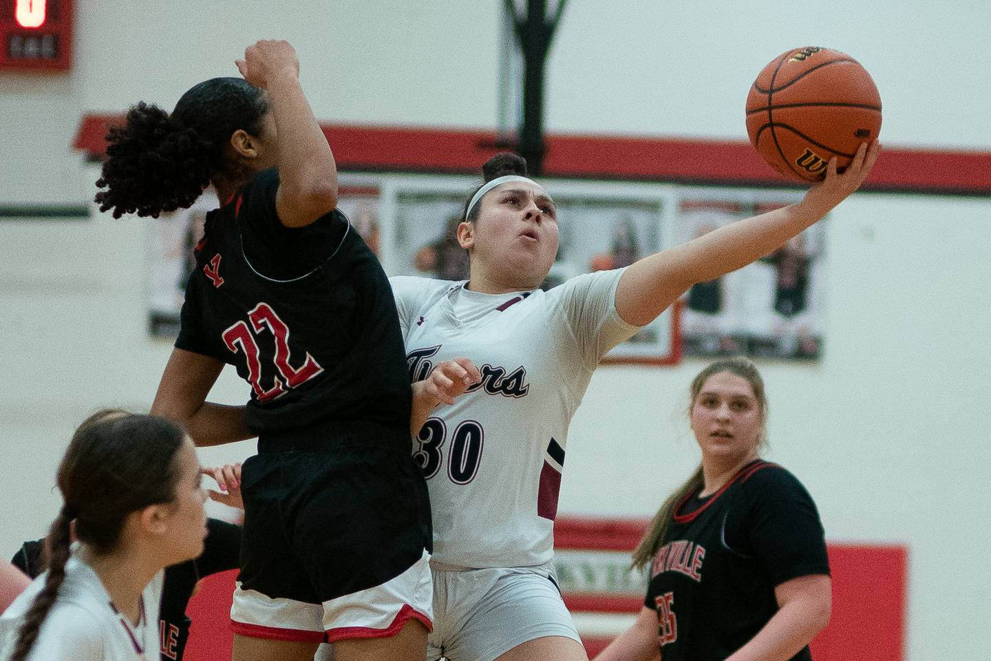 Plainfield North's Lexi Salazar (30) shoots the ball against Yorkville's Alexandra Stewart (22) during a Yorkville girls 4A regional semifinal basketball game at Yorkville High School on Tuesday, Feb 14, 2023.