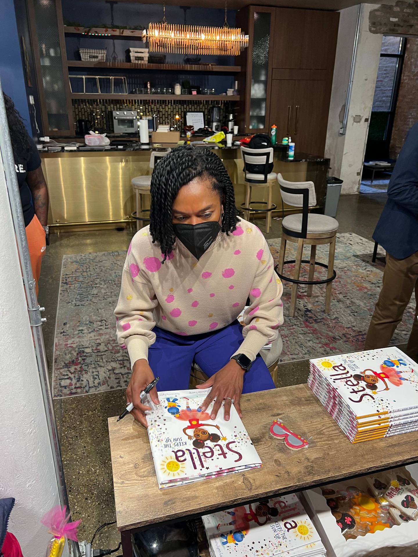 Clothilde Ewing of Chicago is seen signing copies of "Stella Keeps the Sun Up." Ewing wrote the book because she believes children should have access to fun stories about kid experiences featuring diverse characters. The book was released in March 2022.