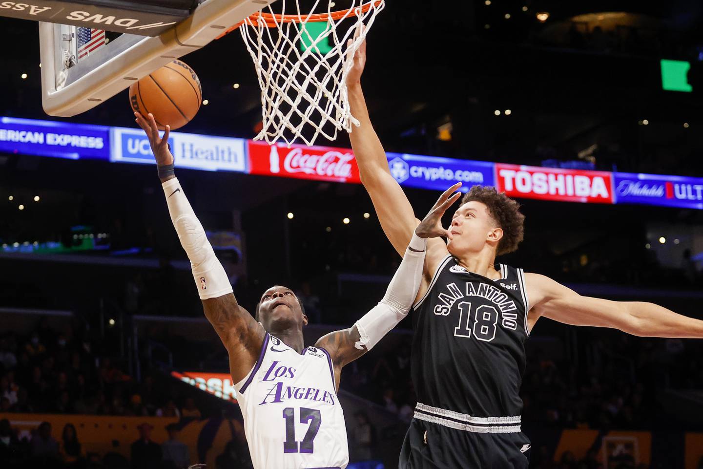 Los Angeles Lakers guard Dennis Schroder, left, goes to basket against San Antonio Spurs forward Isaiah Roby during the first half of an NBA basketball game Sunday, Nov. 20, 2022 in Los Angeles. (AP Photo/Ringo H.W. Chiu)