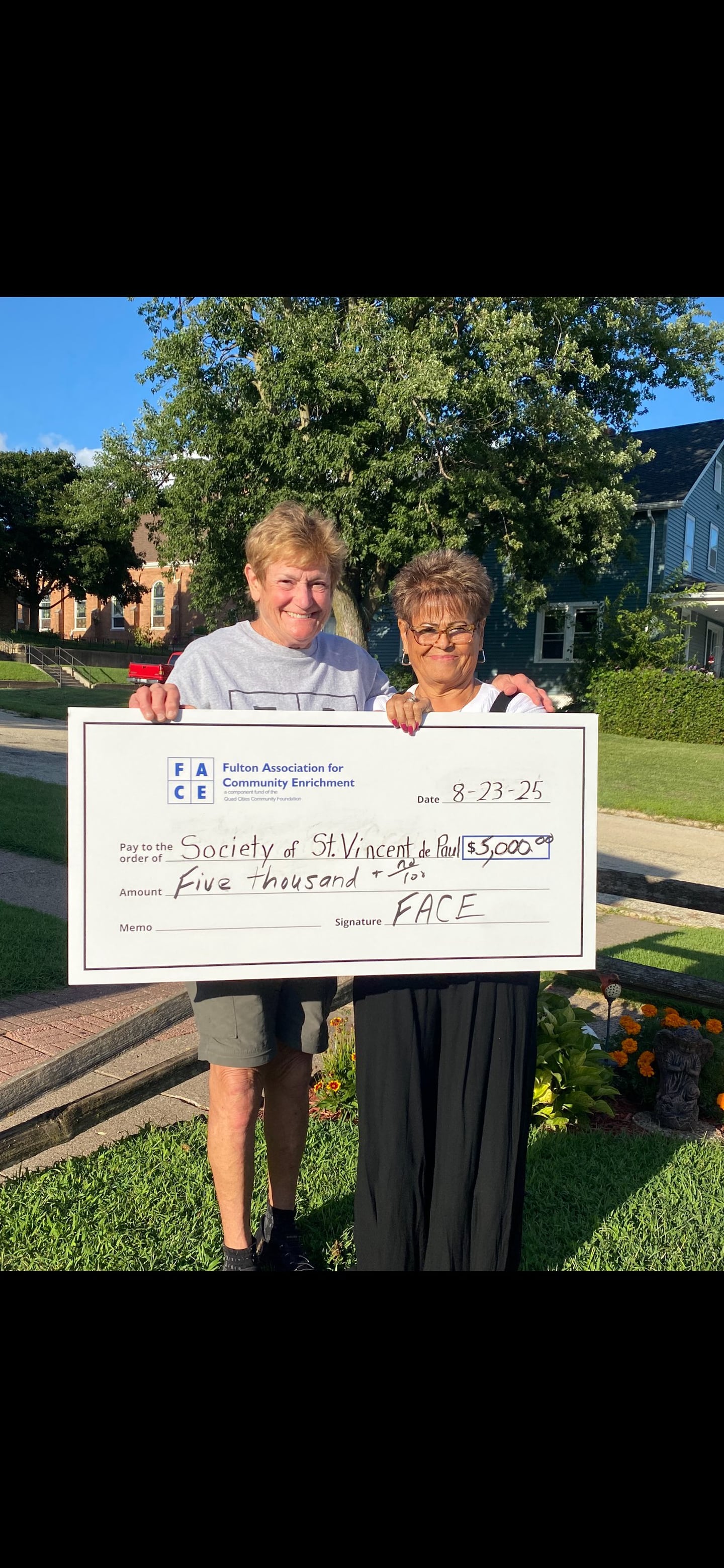 FACE Board member Jean Roeder presents a $5000 check to a representative of the Society of St. Vincent de Paul.