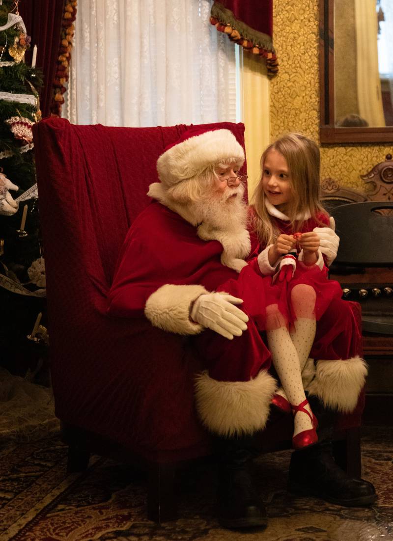Emerson Daly, 5, of Downers Grove tells Santa what she wants for Christmas during the Downers Grove Museum’s Merry & Bright: A Victorian Christmas event on Saturday, Dec. 10, 2022.