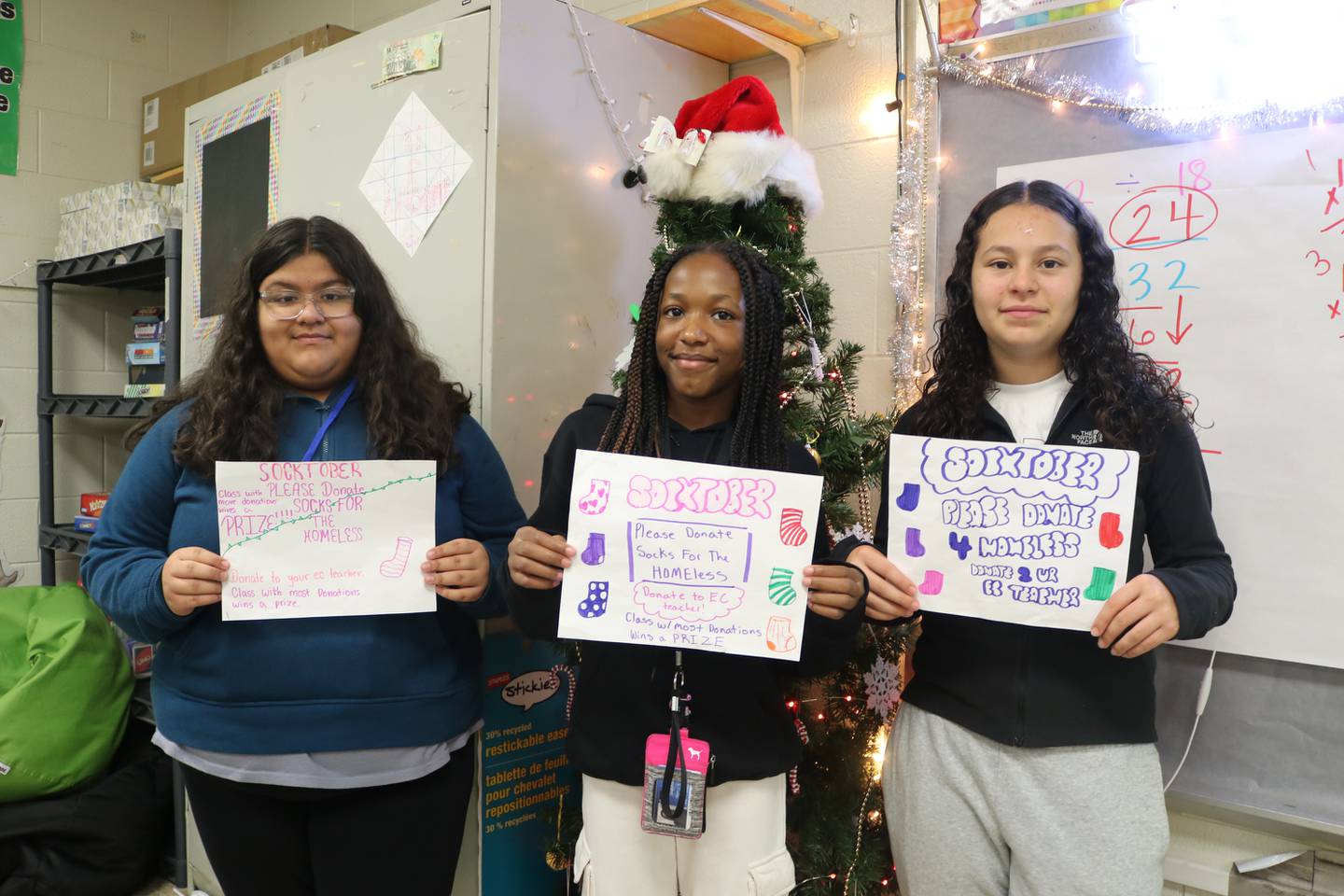 Hufford students Alejandra Ramirez, Leah Collins, and Jimena Ulloa made signs to encourage their classmates and teachers to donate socks.