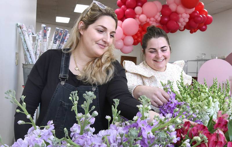 Kat Willrett (left) and Mary Grace McCauley, co-owners of Willrett Flower Company, get the shop set up Wednesday, Feb. 8, 2023, for Saturday’s Downtown DeKalb Sweet Stroll event. The event, which will take place from 1 to 4 p.m. Saturday, will see more than a dozen businesses play host to vendors of speciality sweets, as well as fun activities.
