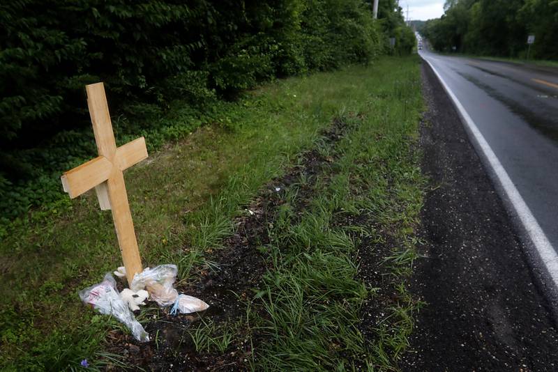 A cross alongside the roadway on July 6, 2025, near Crystal Lake, where a 15-year-old boy was fatally hit by a car the on Wednesday, July 2. Police said the driver fled the scene.