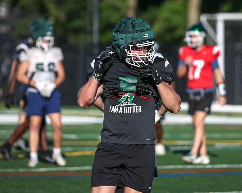 Maximus Hetlet adjusts his headgear in between plays at Glenbard West football practice, Wednesday, Aug 21, 2025  in Glen Ellyn.