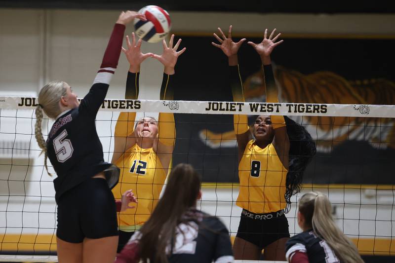 Joliet West’sBrook Schwall, left, and Iyonna Pike go for the block against Plainfield North’s Elizabeth Fitzgerald on Wednesday, Sept. 6, 2023 in Joliet.