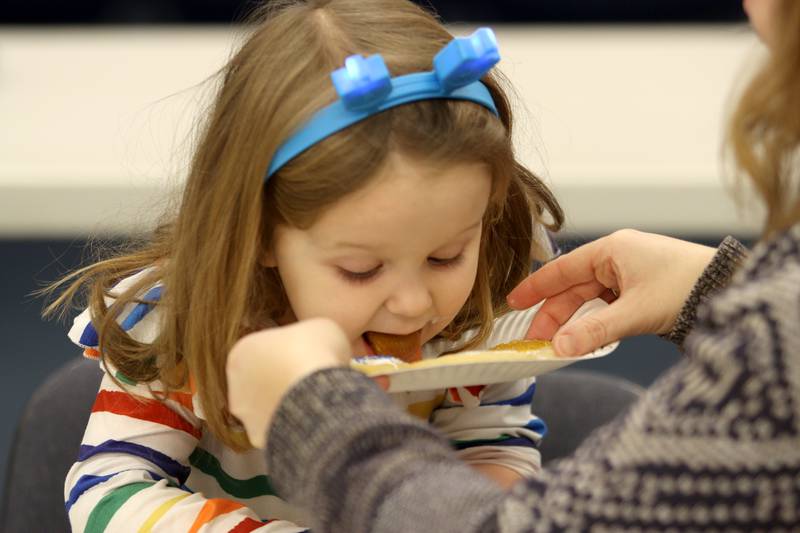 Emmy Pacyna, 3, of Woodstock enjoys every last little bit of  cookie icing during a Chanukah party at The McHenry County Jewish Congregation Sunday.