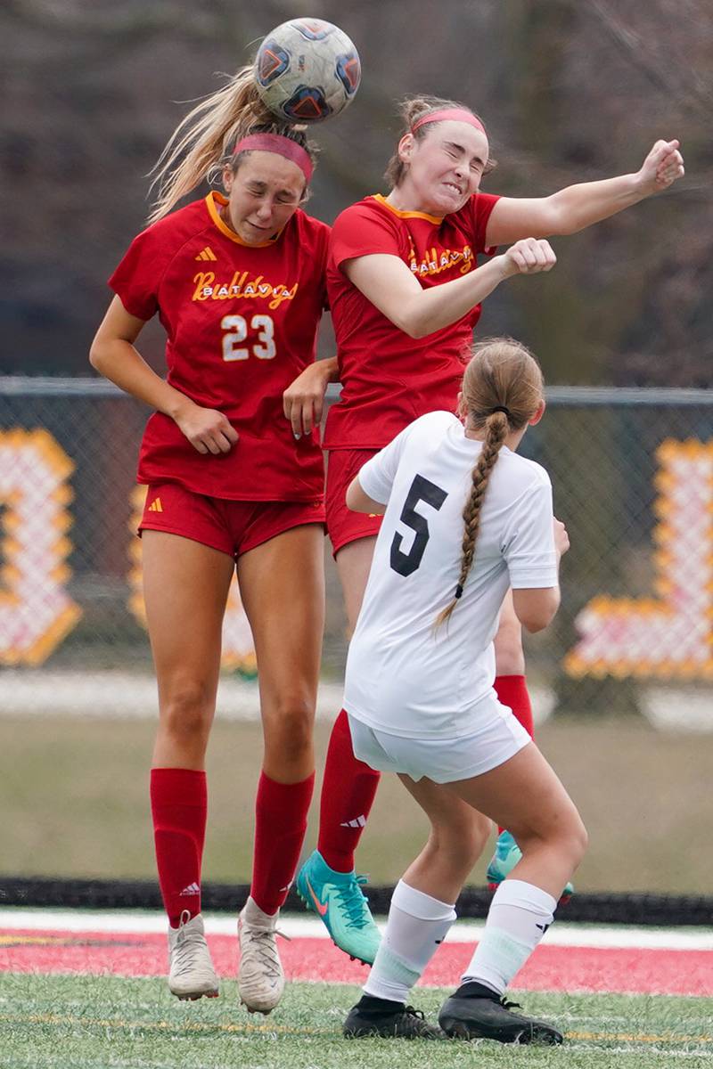 Batavia’s Hannah Hickman (23) goes up for a header against Oswego East's Rachel Kangas (5) during a soccer match at Batavia High School on Saturday, March 29, 2025.