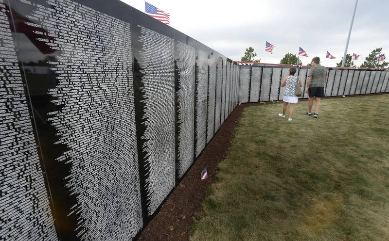 A couple walks the length of the Vietnam Traveling Memorial Wall on Saturday, Aug. 26, 2023, at Veterans Memorial Park in Peru.