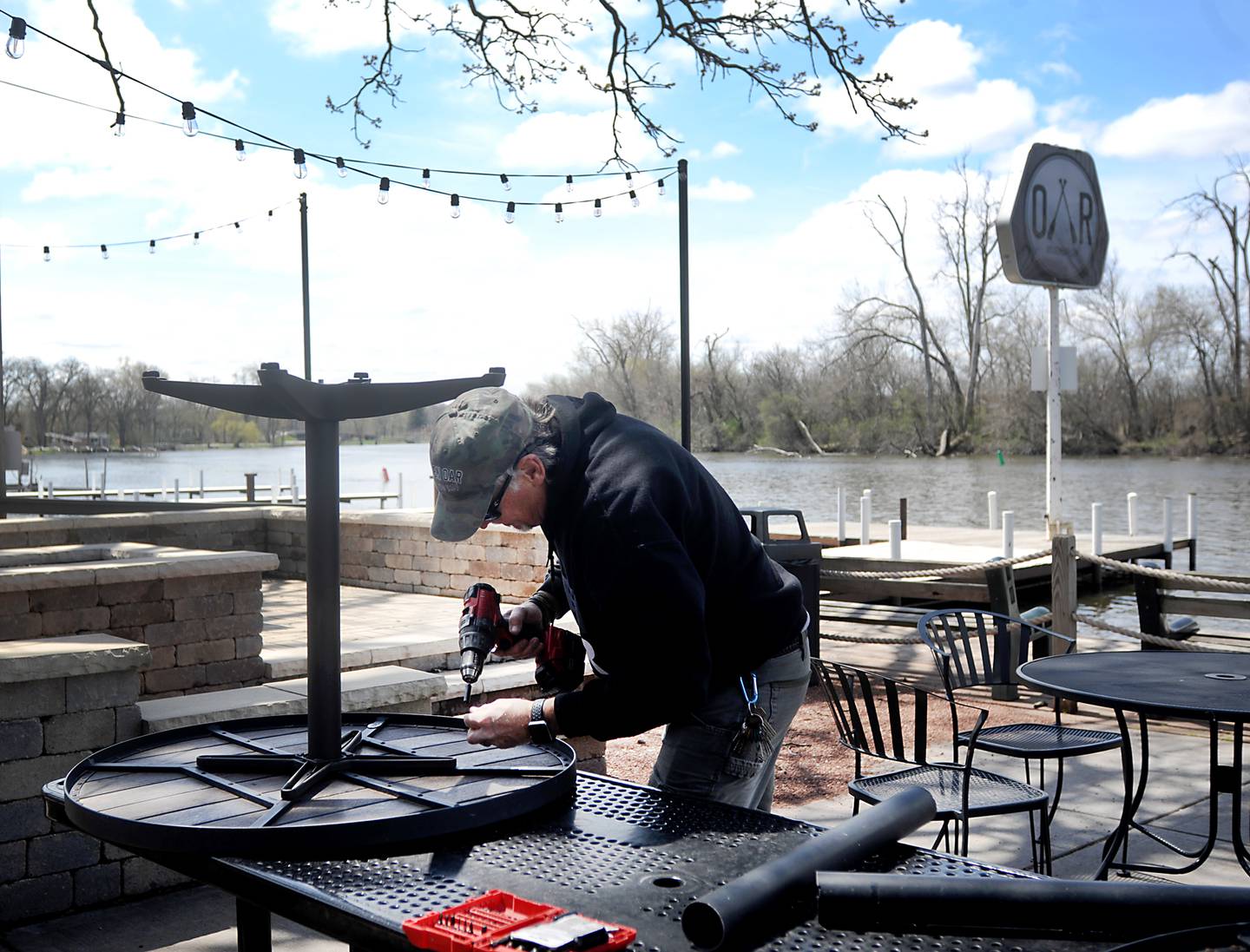 Mike Haber of the Broken Oar, 614 Rawson Bridge Road in Port Barrington, bolts legs on a table top Wednesday, May 4, 2022, as he prepares the outdoor patio for the upcoming summer boating season.