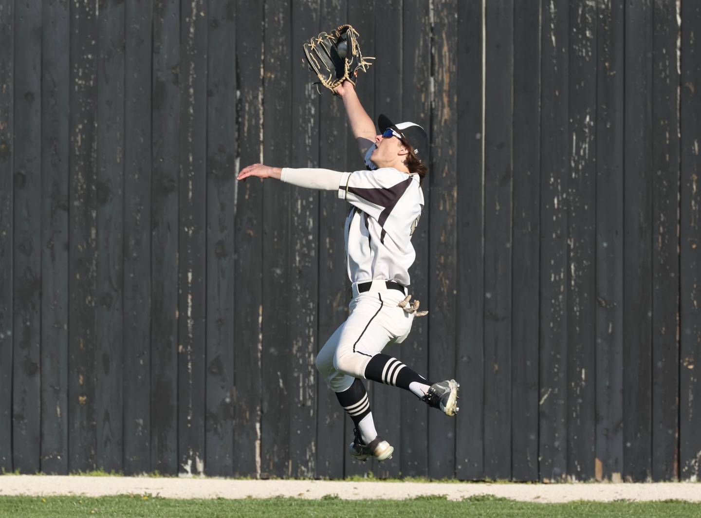 Sycamore's Collin Severson robs an Ottawa hitter of an extra base hit with a leaping grab during their game Friday, April 19, 2024, at the Sycamore Community Sports Complex.
