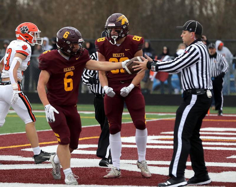 Richmond-Burton's Hunter Carley hands the ball to the referee and Richmond-Burton's Logan Johnson celebrates Carley’s touchdown during an IHSA Class 3A semifinal playoff football game on Saturday, November 22, 2025, at Richmond-Burton High School, in Richmond.