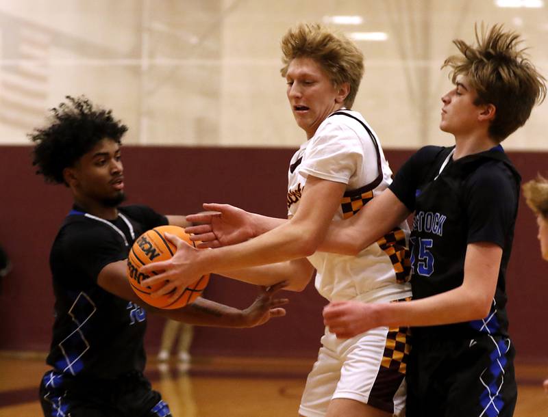 Woodstock's Anthony Grzetic (left) and Liam Laidig (right) battle for a rebound with Richmond-Burton's Luke Robinson (center) during a Kishwaukee River Conference basketball game on Wednesday, Feb. 5, 2025, at Richmond-Burton High School.