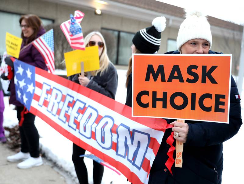Shannon McCormick holds a sign outside the District 99 headquarters in Downers Grove on Monday, Feb. 14, 2022. A large crowd of parents, students and community members who are in favor of a mask choice policy for the high school district gathered outside before the school board meeting.