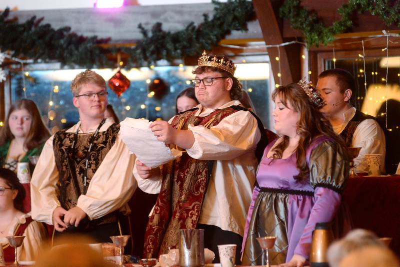 King  (Brady Davis) reads a proclamation as Queen (Abigail Fletcher) and Prince (Isaac Ebert) listen. during the Oregon High School's Madrigal Dinner at the Stronghold Camp & Retreat Center on Saturday, Dec. 9, 2023.