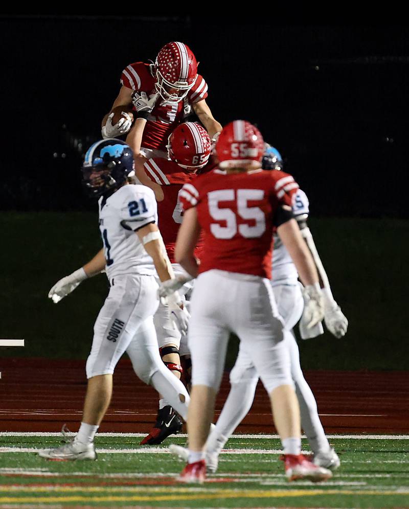 Naperville Central's Aiden Clark is hoisted in the air after a long 60+ yard touchdown run Friday October 27, 2023 in Naperville.