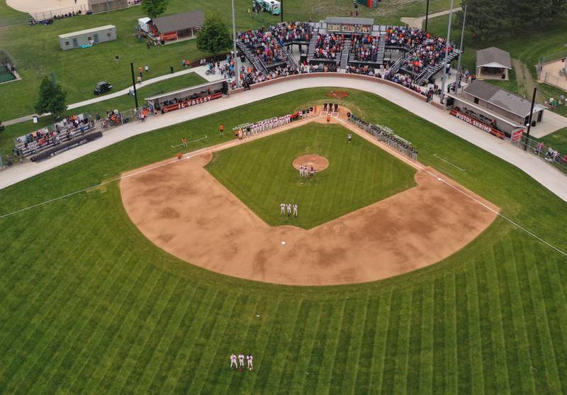 Members of the Illinois Valley Pistol Shrimp and Normal Corn Belters stand for the National Anthem during the Illinois Valley Pistol Shrimp home opener on Friday, May 30, 2025 at Schweickert Stadium in Peru.