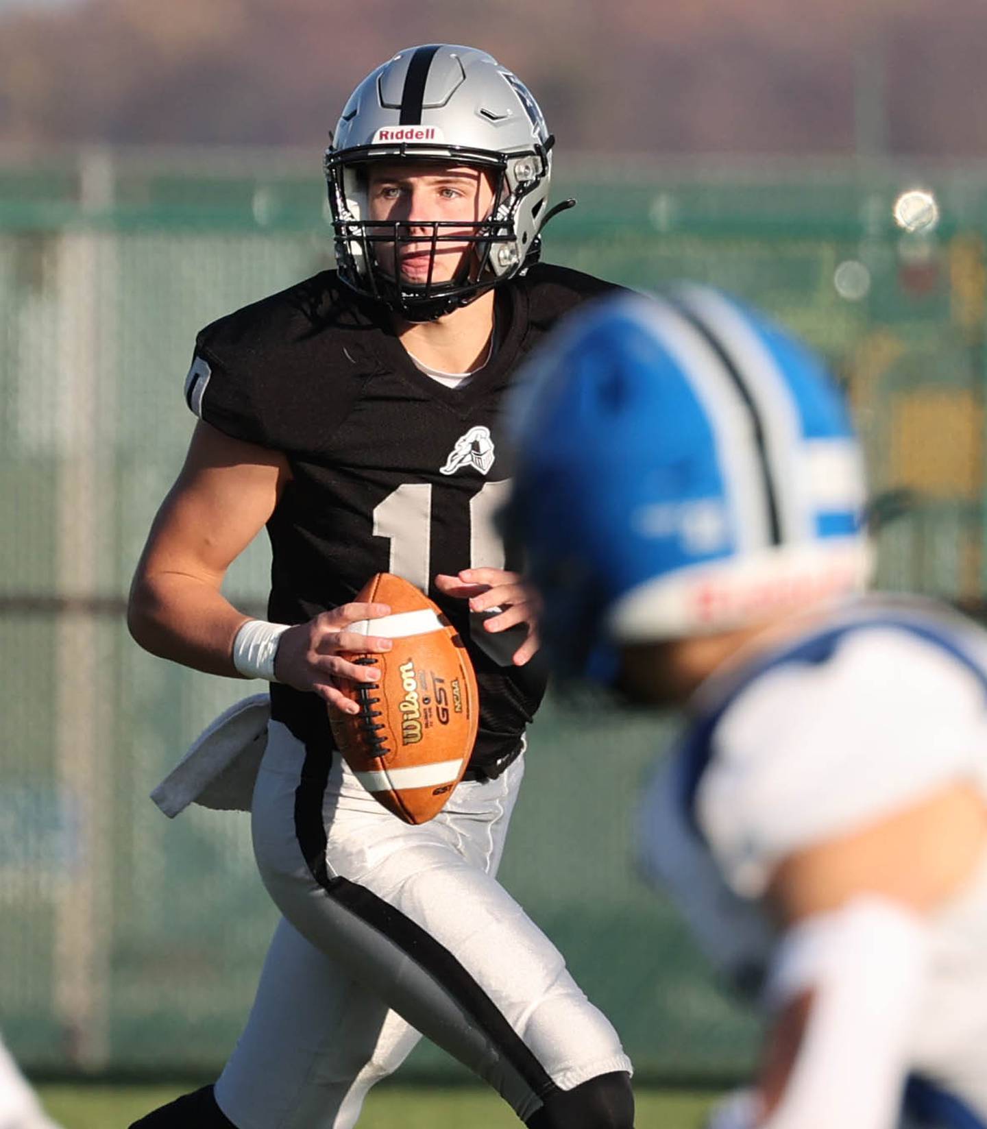 Kaneland's Troyer Carlson looks for a receiver as he rolls away from the Lake Zurich pass rush Saturday, Nov. 4, 2023, during their Class 6A second round playoff game at Kaneland High School in Maple Park.