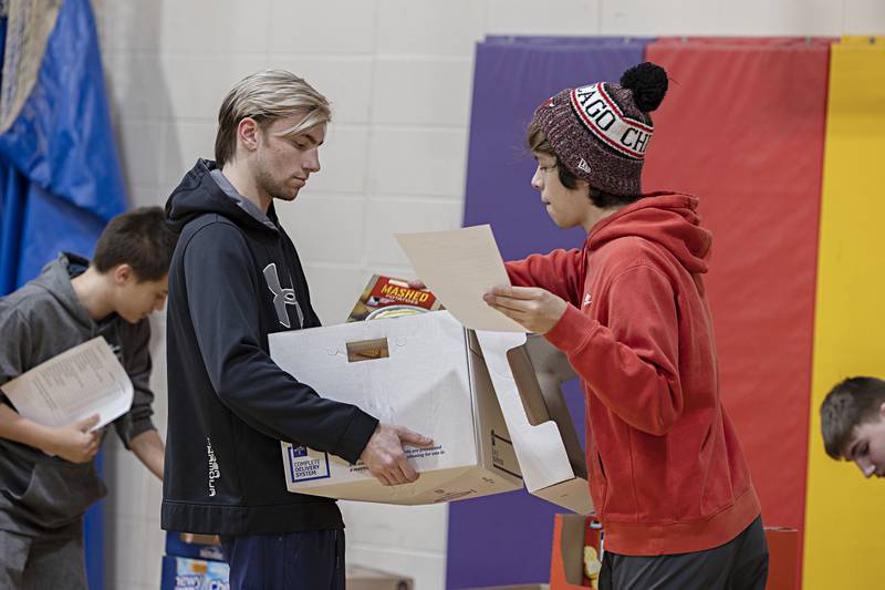 Brayden Bock (left) and Ethan Harrington load up a box Tuesday, Dec. 20, 2022 at the Dixon YMCA.