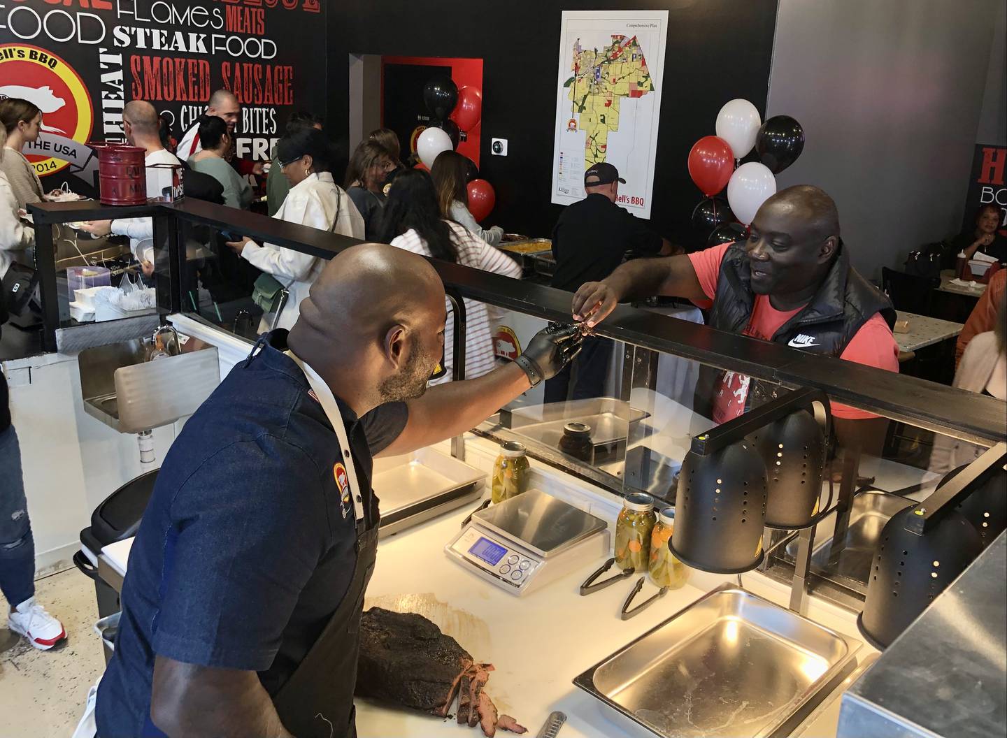 Hell's BBQ owner Keith Richards handing out samples as he slices his brisket at a friends and family event Oct. 30 2022.