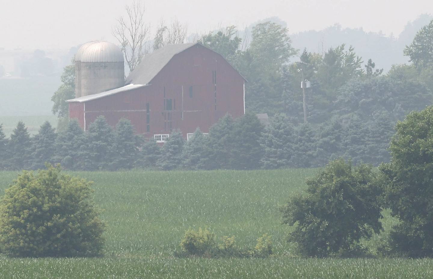 A farm is partially obscured by haze from the Canadian wildfires Wednesday, June 28, 2023, in Cortland Township. Smoke from the fires in Canada has moved south into Illinois causing poor air quality that may be unhealthy especially to those with sensitive respiratory systems.