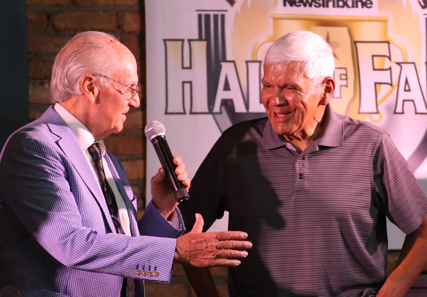 John Cruz, a legendary area baseball coach and recipient of the Lanny Slevin Lifetime Achievement Award chats with emcee Lanny Slevin during the 2025 Shaw Media Illinois Valley Sports Hall of Fame at the Auditorium Ballroom in La Salle.