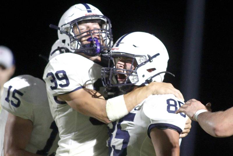 Cary-Grove’s Holden Boone, left, greets Luca Vivadelli in the end zone following a Trojan touchdown in varsity football at Metcalf Field in Crystal Lake Friday night.