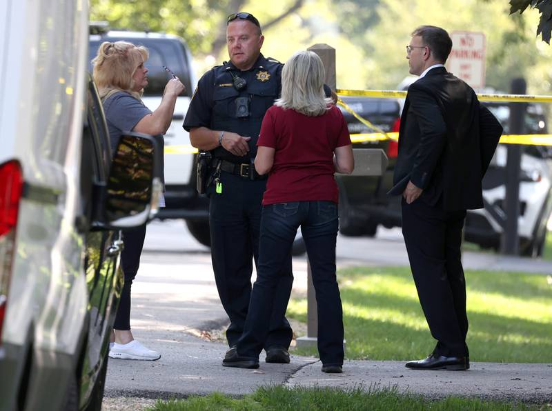 DeKalb County sheriff’s deputies and other investigators talk Tuesday, Sept. 30, 2025, in the driveway of a house in the 1300 block of Oakland Drive in Sycamore where two people were found dead Tuesday morning.