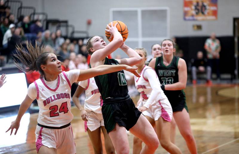 Glenbard West's Julia Benjamin shoots the ball past Batavia's Hallie Crane during the Class 4A St. Charles East Sectional final on Thursday, Feb. 27, 2025 in St. Charles.
